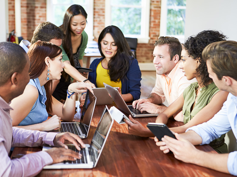 Photo of a team working together on their laptops